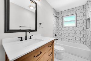 After A bathroom with black and white tile and a toilet, featuring East Chicago siding.