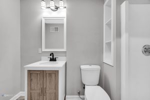 After A small bathroom with a toilet and sink, featuring Munster interior remodeling.